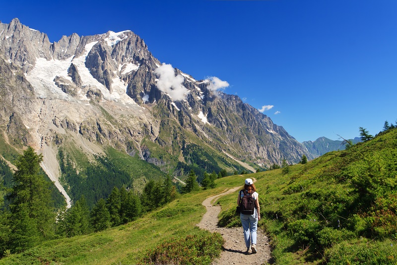 Hiker in Ferret Valley with Mont Blanc in background, Aosta Valley, Italy